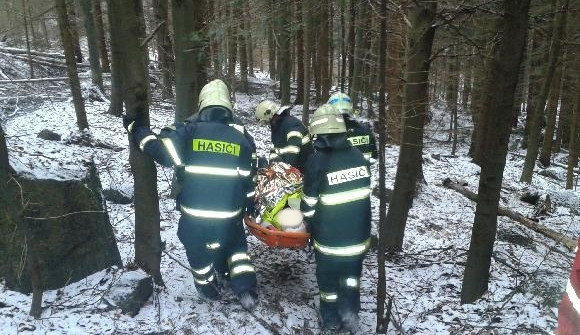 Hasiči transportují poraněného muže. Foto: HZSLK