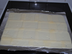 Plátky po vyndání z trouby. Teď je nutné trefit chvíli, kdy půjde sýr nejlépe sundat z alobalu.