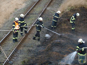 Hořící louka zpomalila železniční dopravu v Hrádku