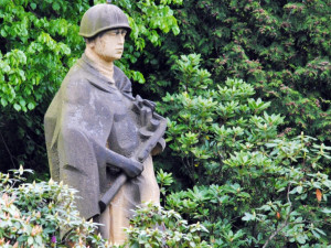 Vojín stojí v rohu vojenského hřbitova