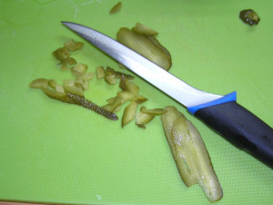 Krájení kyselé okurky.