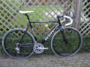 závodní silniční kolo SCOTT, černé barvy, hmotnost 8,8 kg, hliníkový rám 6061 s karbonovou přední vidlicí, výška rámu 56cm, 9 rychlostní zařízení Shimano Claris, nové sedlo