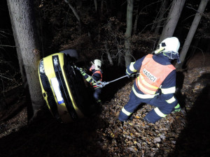 Těžká technika musela večer vyprošťovat auto z lesa. Řidič skončil v nemocnici