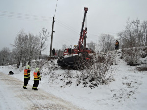 Luxusní BMW hrozilo pádem na chalupu, vyprostit ho musel až jeřáb hasičů