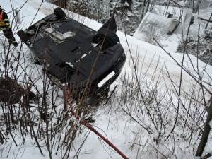 Luxusní BMW hrozilo pádem na chalupu, vyprostit ho musel až jeřáb hasičů