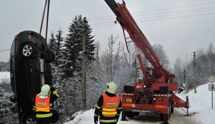 Luxusní BMW hrozilo pádem na chalupu, vyprostit ho musel až jeřáb hasičů