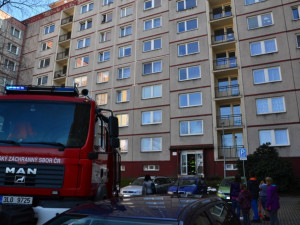 Hasič slaňuje do pátého patra paneláku v Dobiášově ulici.