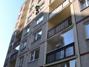 Hasič slaňuje do pátého patra paneláku v Dobiášově ulici.