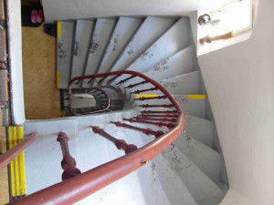 Vřetenové schodiště skládané z kamenných stupňů doplněné litinovým zábradlím pochází z doby rozšíření domu v 70. letech 19. století.