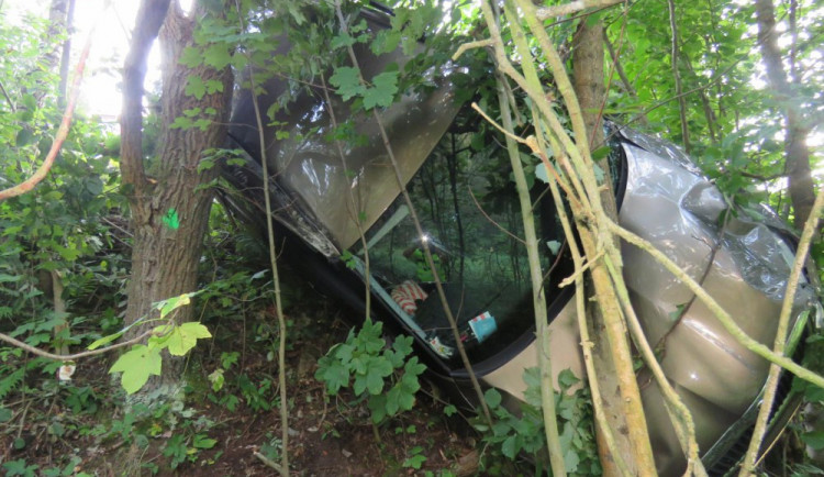 Řidič skončil s autem zaklíněný mezi stromy.