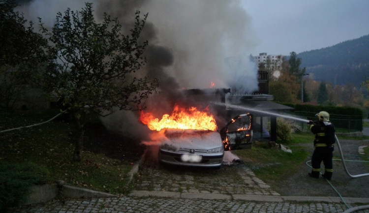 Hořící auto a přístavek.