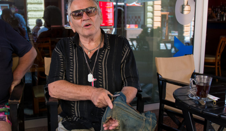 Petr Šída ukazuje díry, které v džínách zůstaly po nábojích