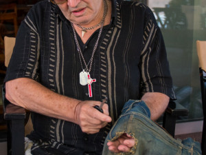 Petr Šída ukazuje díry, které v džínách zůstaly po nábojích