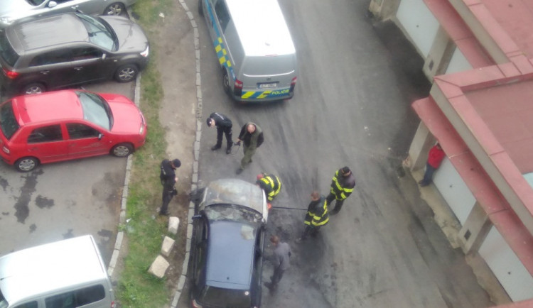 Hasiči s policisty zjišťují, proč auto začalo hořet.