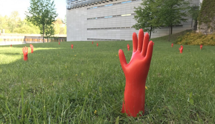 Červené ruce vylézají ze země.