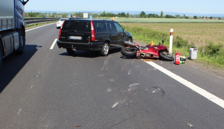 Motorkář předjížděl kolonu na dálnici po středové čáře. Srazil se s autem a skončil v nemocnici