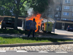 Na Dobiášovce shořelo stání s kontejnery. Žár poškodil i vedle zaparkované auto