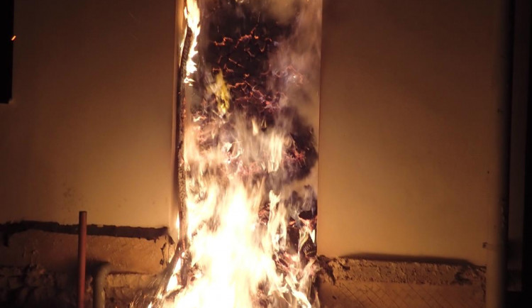 Hořící přístřešek plný dřeva