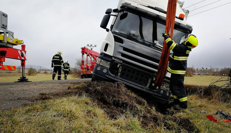 Náklaďák uvízl v příkopu a hrozilo jeho převrácení. Hasiči použili jeřáb