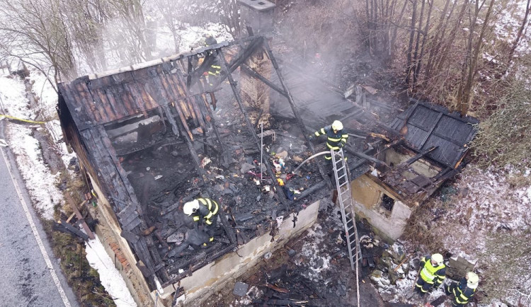 Z domu po požáru zbyly jen obvodové zdi. Hasiči kvůli zásahu uzavřeli silnici
