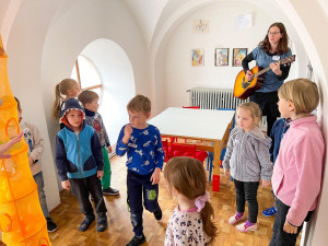 Koordinátorka projektu Zdeňka Matějková hraje dětem na kytaru.