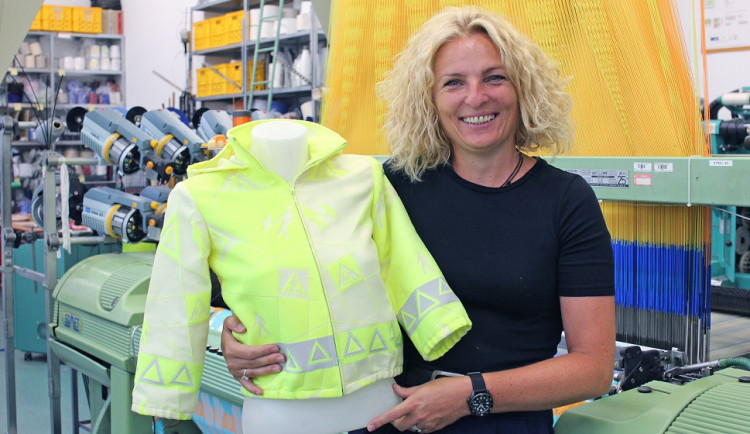 Brigita Kolčavová u tkacího stroje s elektronickými žakárskými prošlupními mechanismy a s prototypem vesty s bezpečnostními prvky