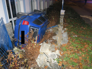 Mladý řidič nezvládl jízdu a havaroval. Prorazil plot a auto skončilo na boku opřené o dům