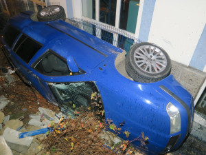 Mladý řidič nezvládl jízdu a havaroval. Prorazil plot a auto skončilo na boku opřené o dům