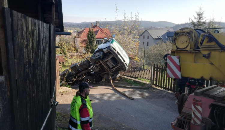 Bagr sjel z korby náklaďáku.