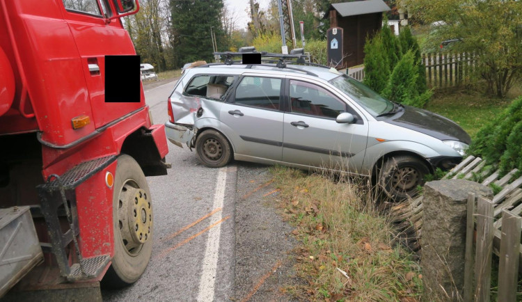Řidič nedal přednost Tatře. Náraz odhodil auto na plot domu