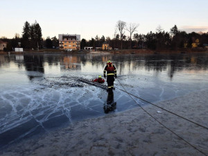 Auto zmizelo pod led rybníka. Hasiči se ho snaží z vody vyprostit