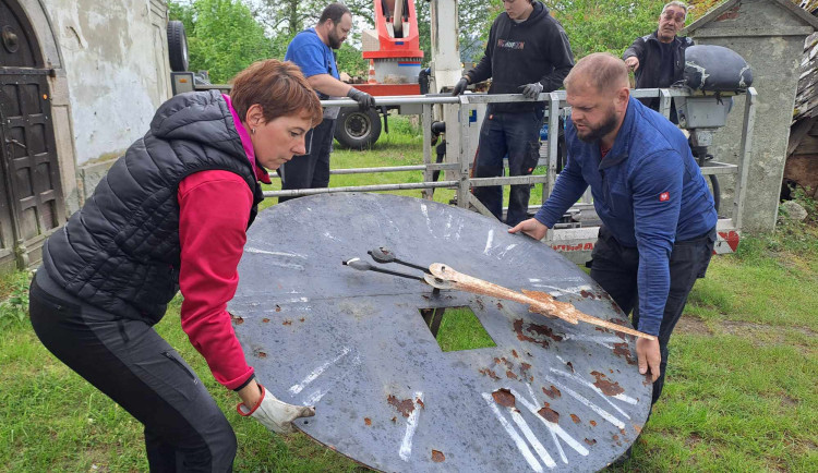 Hodinářka Marie Nesnídalo s kolegy při snášení jednoho z ciferníků.