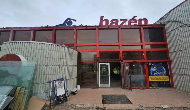 Exteriér bazénu – čelní část objektu má odstraněné vstupní dveře a část fasády. Zahájila se demontáž opláštění budovy. Zmizela také charakteristická "vlnka" nad vstupem, která však nebyla součástí původního návrhu bazénu.