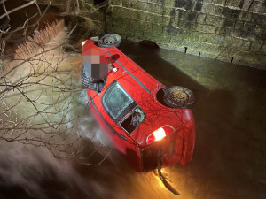Kuriozní nehoda v Liberci. Řidič sjel v noci autem do Nisy, na hasiče čekal usazený na okénku
