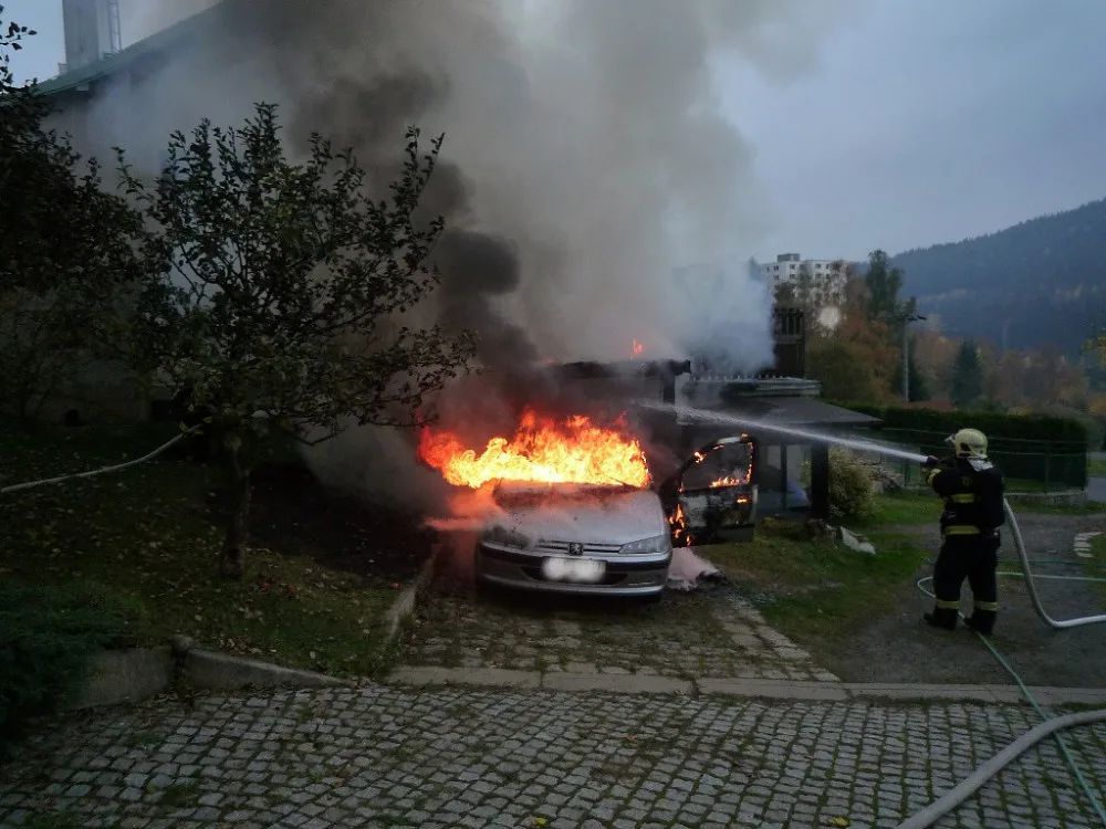 Hořící auto a přístavek.