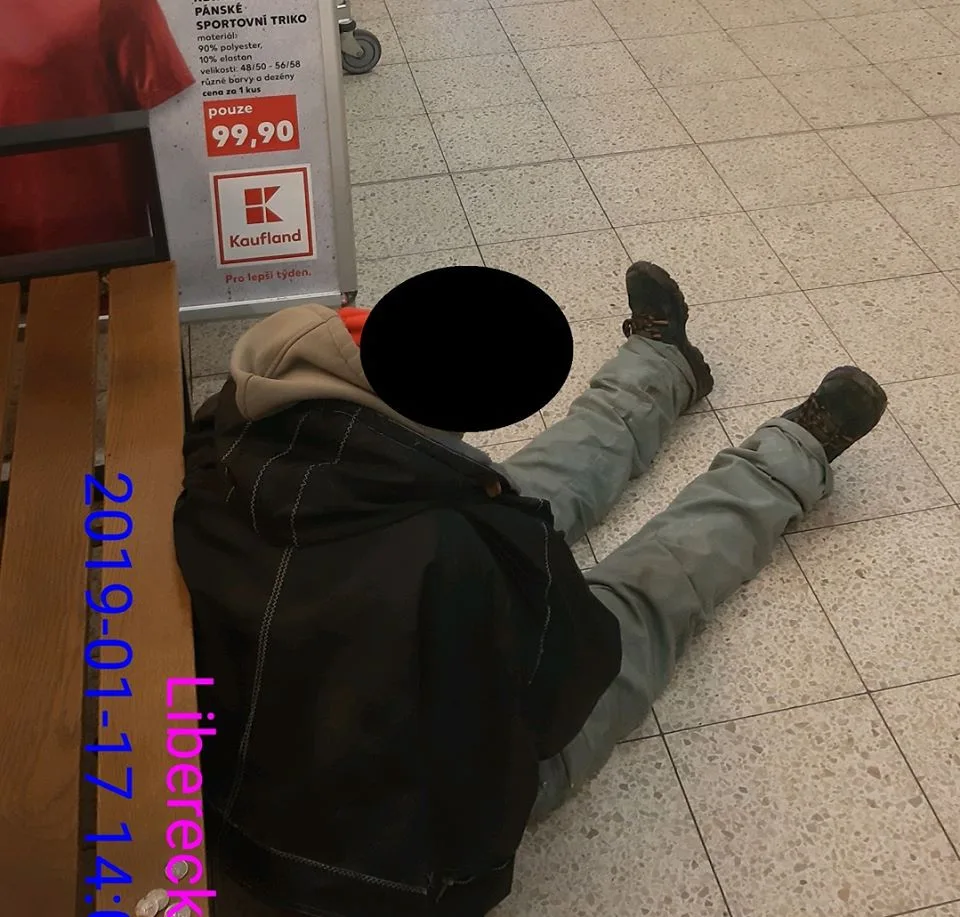 Bezdomovec usnul za pokladnami na zemi.