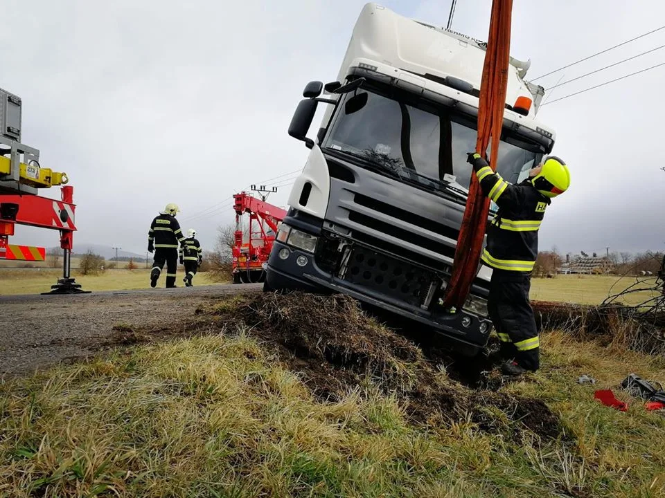 Náklaďák uvízl v příkopu a hrozilo jeho převrácení. Hasiči použili jeřáb