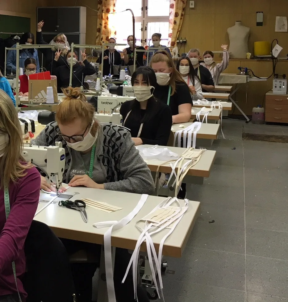 Studenti i pedagogové tvoří roušky.