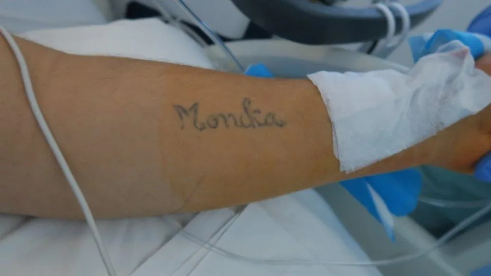 Muž má na levém předloktí tetování.