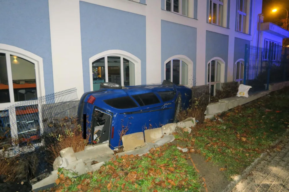 Mladý řidič nezvládl jízdu a havaroval. Prorazil plot a auto skončilo na boku opřené o dům