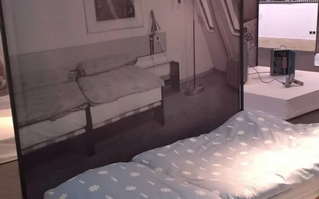 Postel i s povlečením, na kterém jsou vločky a písmeno J.