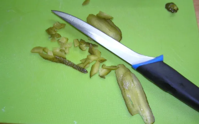 Krájení kyselé okurky.