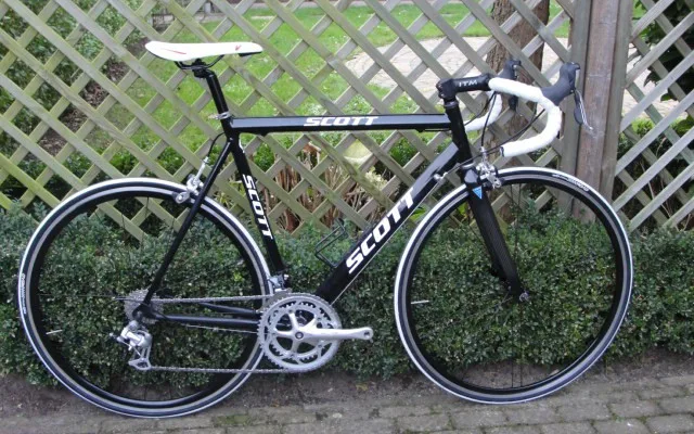 závodní silniční kolo SCOTT, černé barvy, hmotnost 8,8 kg, hliníkový rám 6061 s karbonovou přední vidlicí, výška rámu 56cm, 9 rychlostní zařízení Shimano Claris, nové sedlo