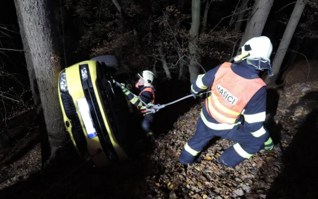 Těžká technika musela večer vyprošťovat auto z lesa. Řidič skončil v nemocnici