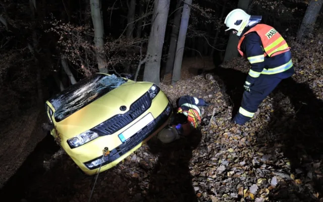 Těžká technika musela večer vyprošťovat auto z lesa. Řidič skončil v nemocnici