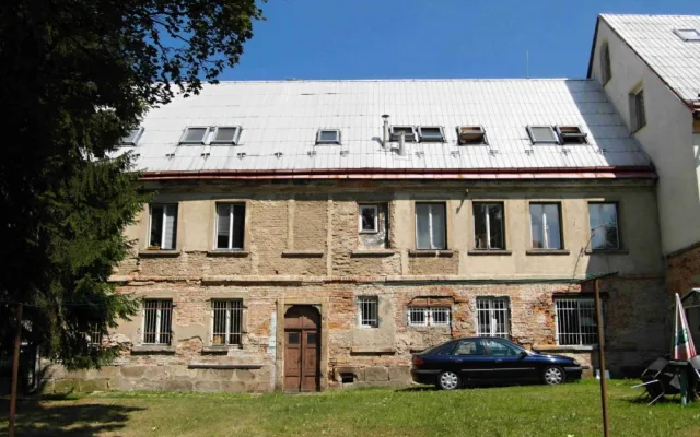 Na zahradní fasádě je i před novodobě dozdívky zřejmé originální řešení okenních os, pod opadanou omítkou je patrné materiálové řešení konstrukce se soklem z kamenných kvádrů a cihlovými zdmi.