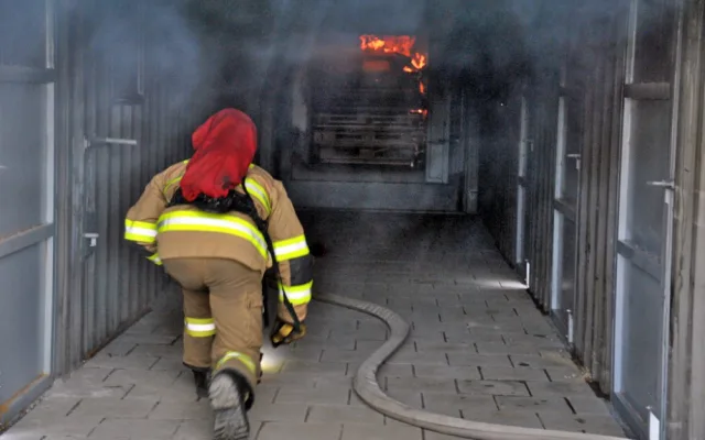 Vedoucí výcviku míří k ohni