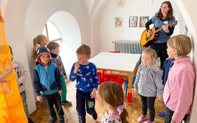 Koordinátorka projektu Zdeňka Matějková hraje dětem na kytaru.