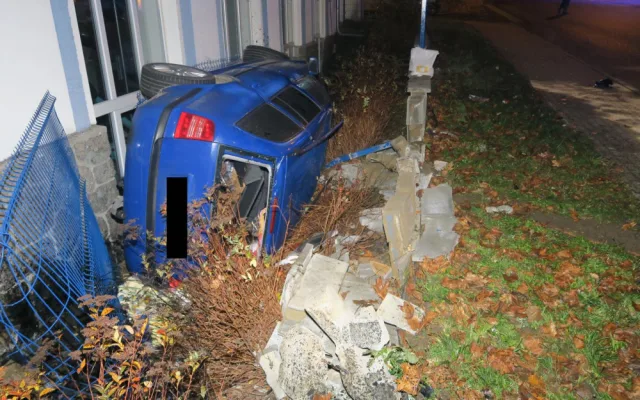 Mladý řidič nezvládl jízdu a havaroval. Prorazil plot a auto skončilo na boku opřené o dům