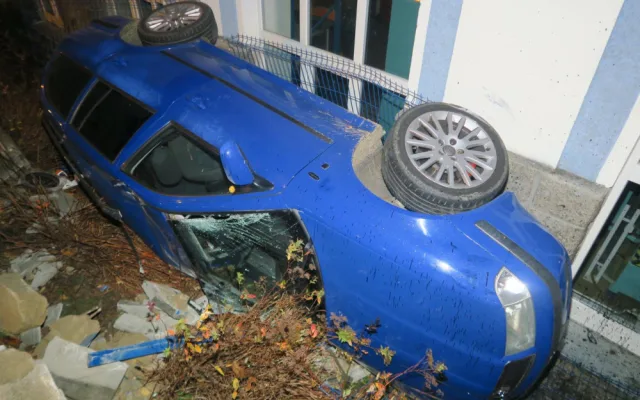 Mladý řidič nezvládl jízdu a havaroval. Prorazil plot a auto skončilo na boku opřené o dům